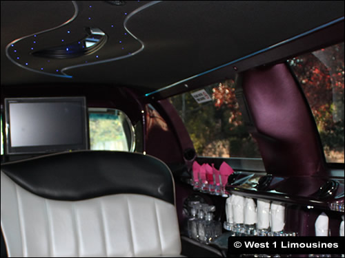 View of tinted windows, TV screens and bar area inside limo